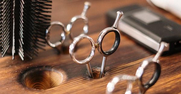 A pair of scissors sitting on top of a wooden table.