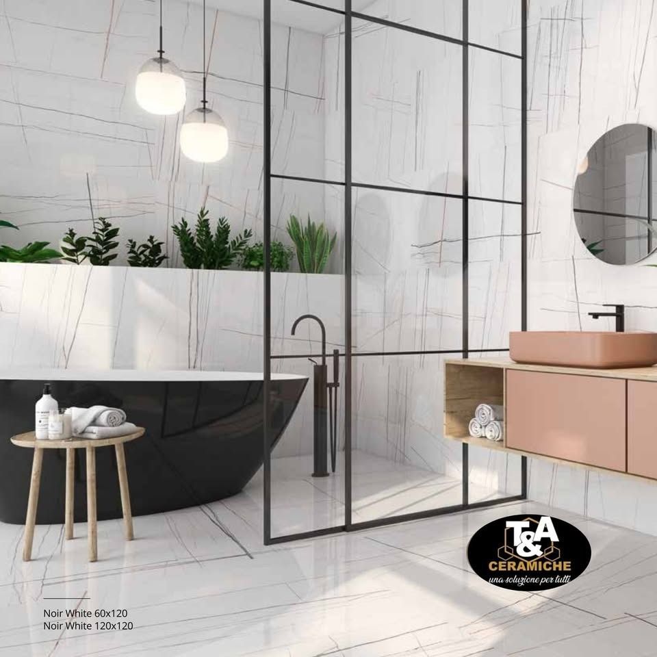 Bagno moderno con vasca nera, porta doccia in vetro e mobiletto rosa.
