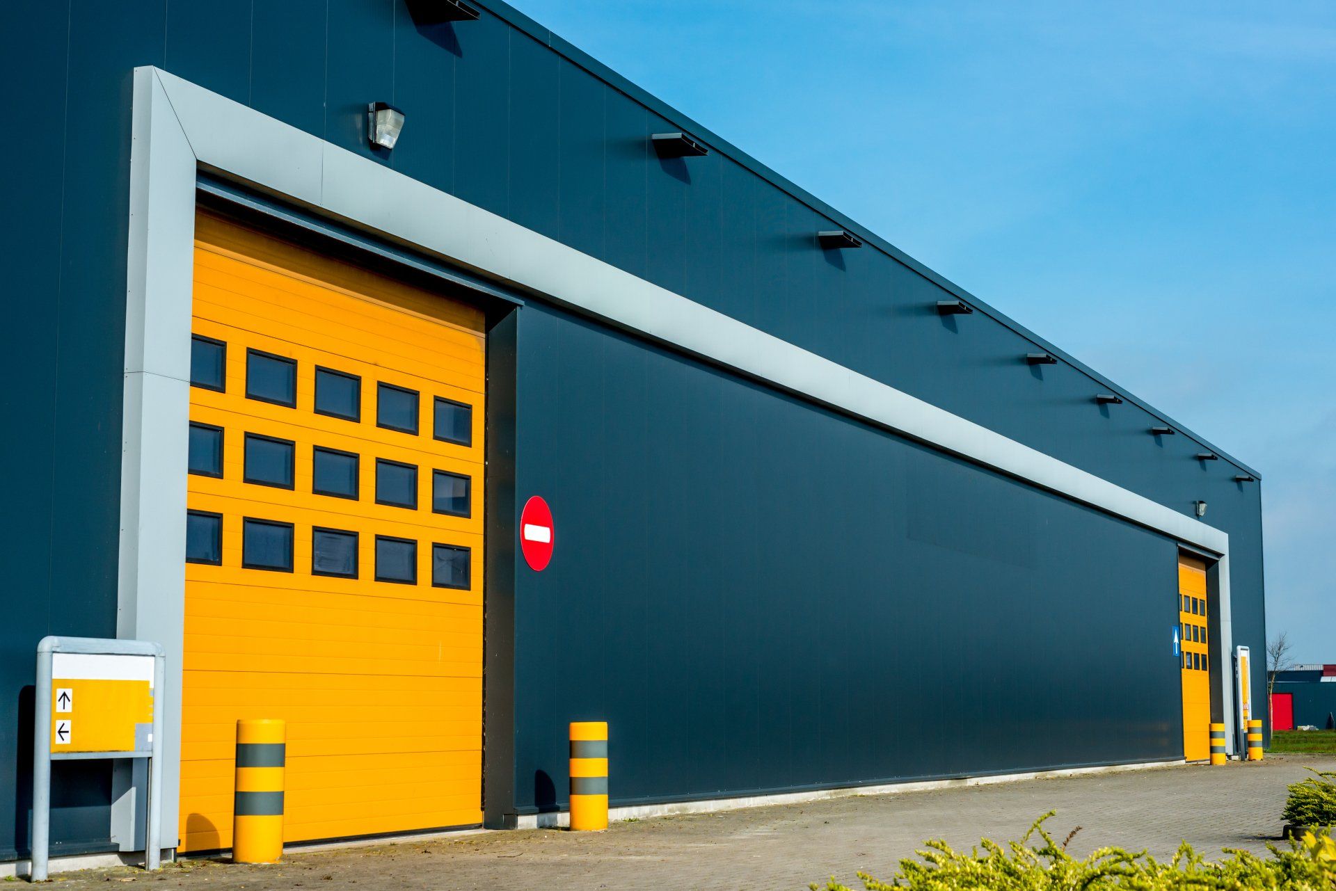 a large warehouse with a yellow garage door and a no entry sign .