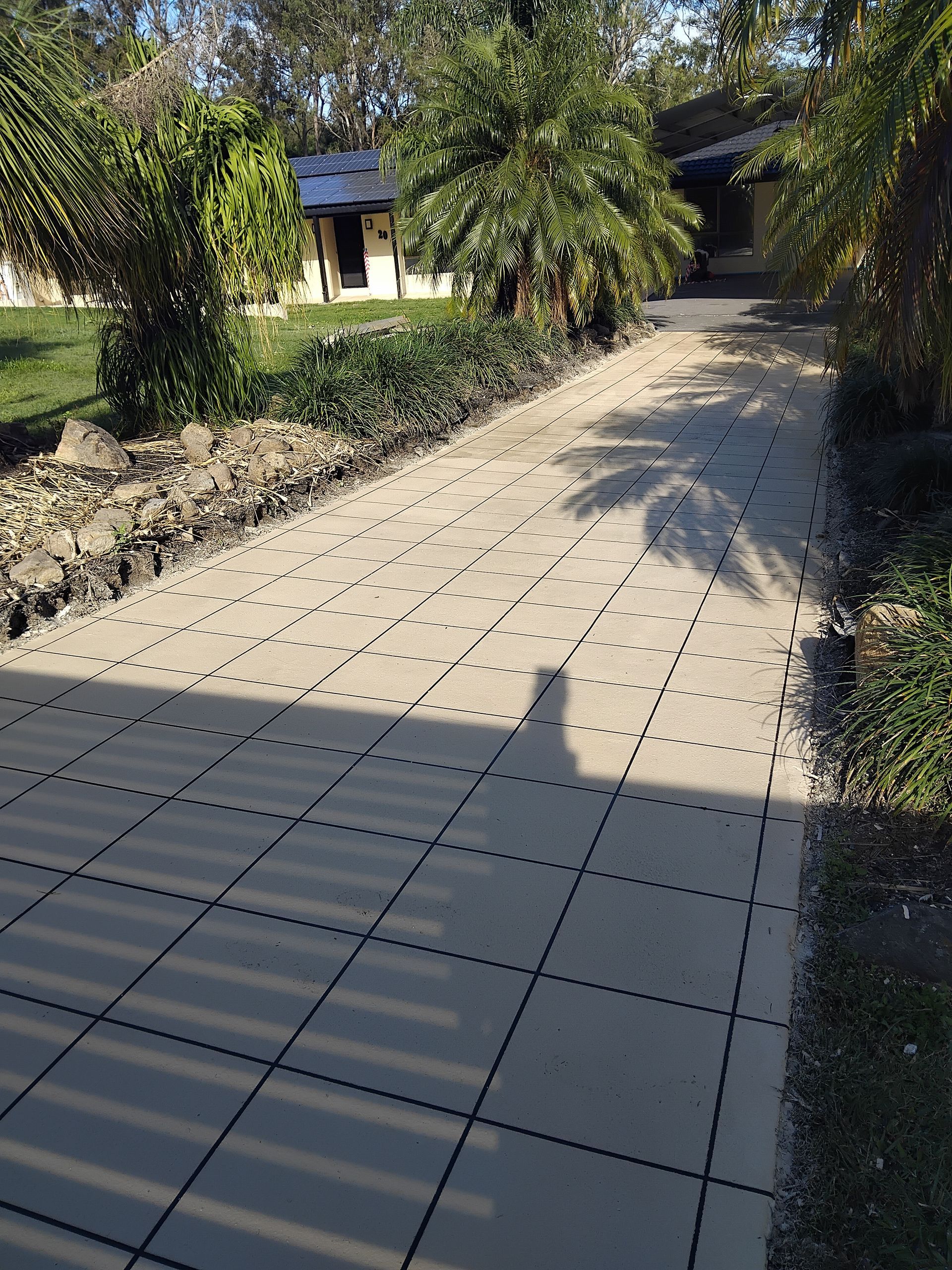 A Yellow Blower is Sitting on the Sidewalk in Front of a House — Troys Concrete Overlays in Hillcrest, QLD