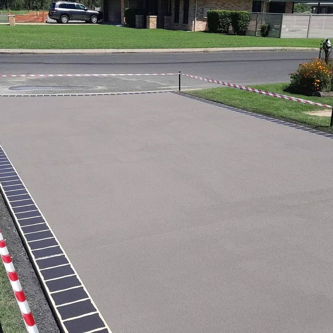 A Car is Parked in a Driveway Next to a House — Troys Concrete Overlays in Hillcrest, QLD