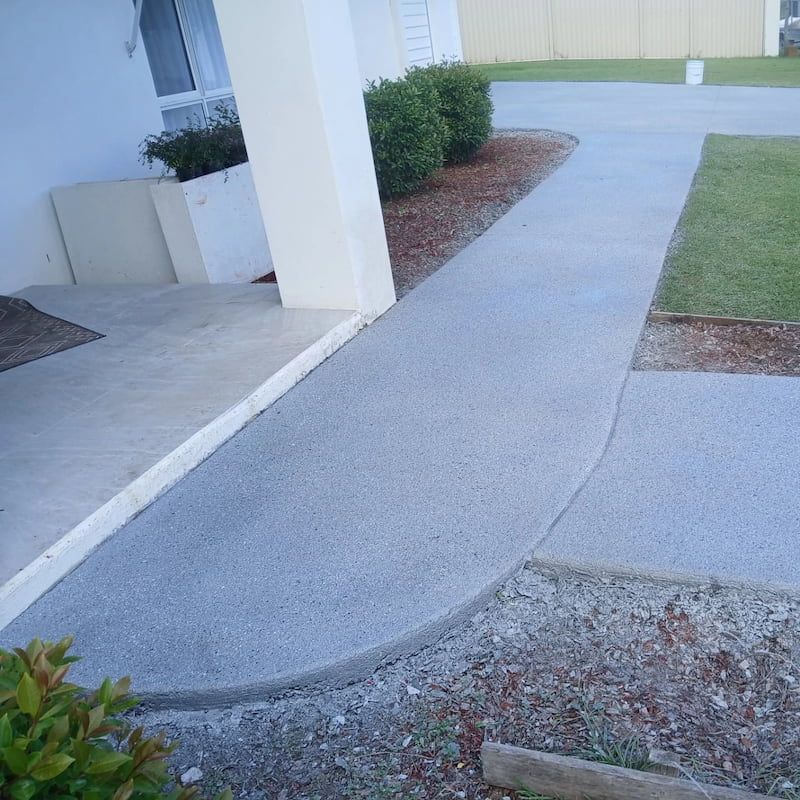 A Concrete Walkway Leading to a House With a Fence in the Background — Troys Concrete Overlays in Hillcrest, QLD