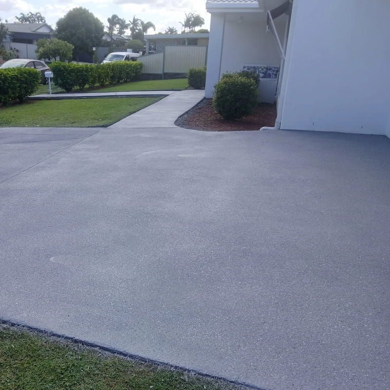 A Concrete Driveway in Front of a White House — Troys Concrete Overlays in Hillcrest, QLD