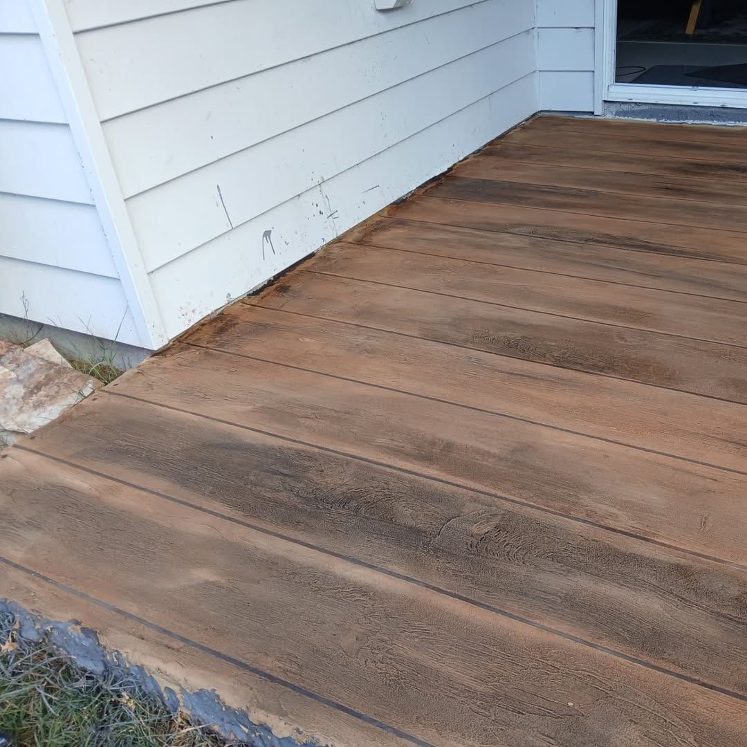 Wooden-look Concrete Patio Next to White Siding — Troys Concrete Overlays in Hillcrest, QLD