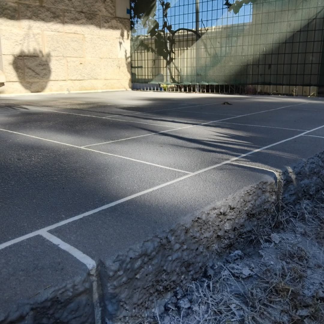 Asphalt Sports Court With White Lines, Shadowed Wall, and Chain-link Fence — Troys Concrete Overlays in Hillcrest, QLD