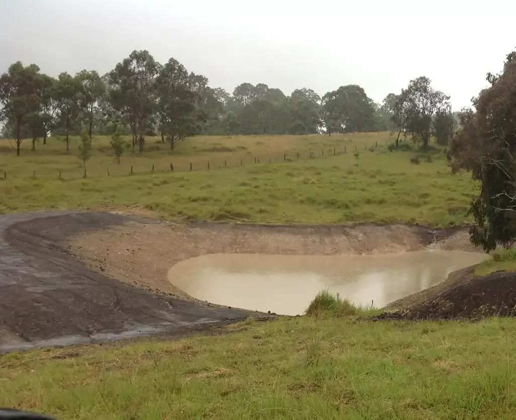 A Pond With Grassy Field Connected to Dam — S M & A J Gilbert Earthmoving in Mitchells Island, NSW