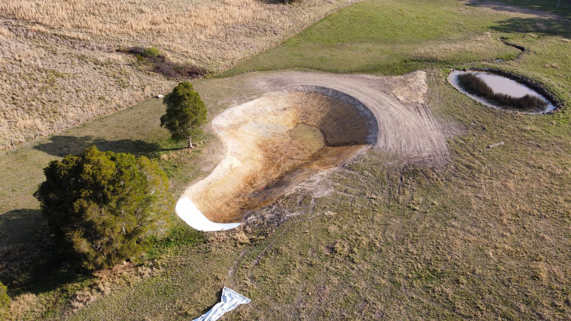 Aerial View of a Dry, Light-coloured Earthwork Structure on a Hillside — S M & A J Gilbert Earthmoving in Mitchells Island, NSW