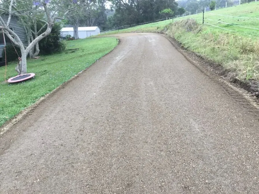 A Road With a Dead Tree Going Through a Grassy Field — S M & A J Gilbert Earthmoving in Mitchells Island, NSW