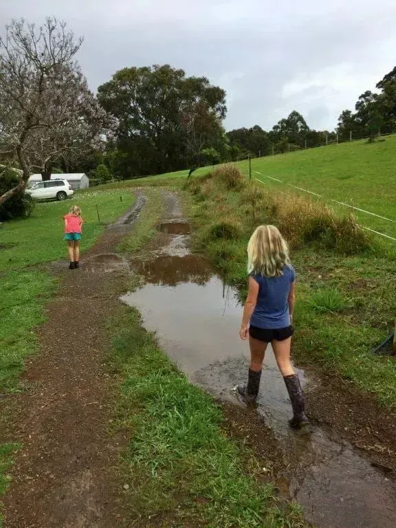 A Girl is Walking in a Muddy Puddle on a Dirt Path — S M & A J Gilbert Earthmoving in Mitchells Island, NSW