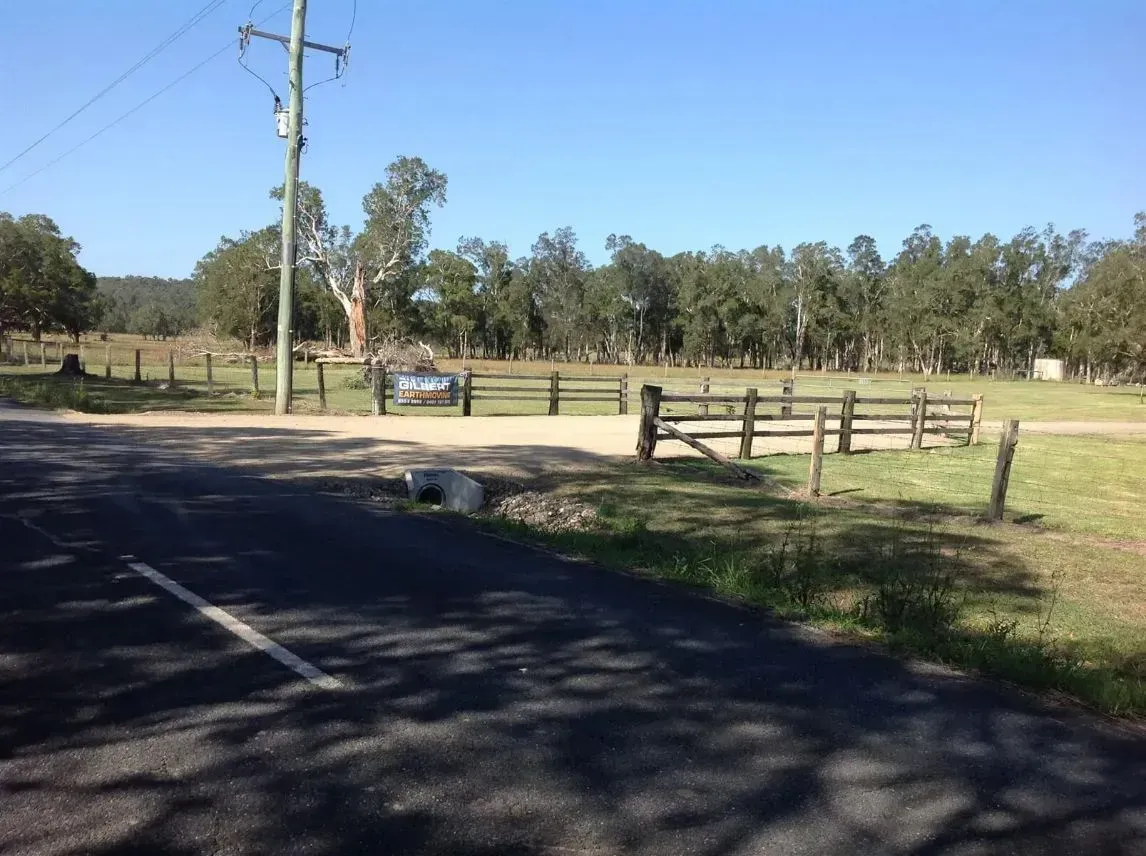 A Road With a Wooden Fence And Electric Post — S M & A J Gilbert Earthmoving in Mitchells Island, NSW
