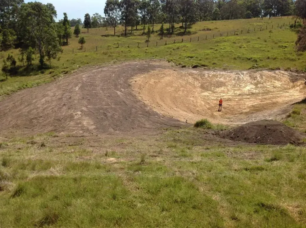A Rough Roads With A Man In A Crater — S M & A J Gilbert Earthmoving in Mitchells Island, NSW
