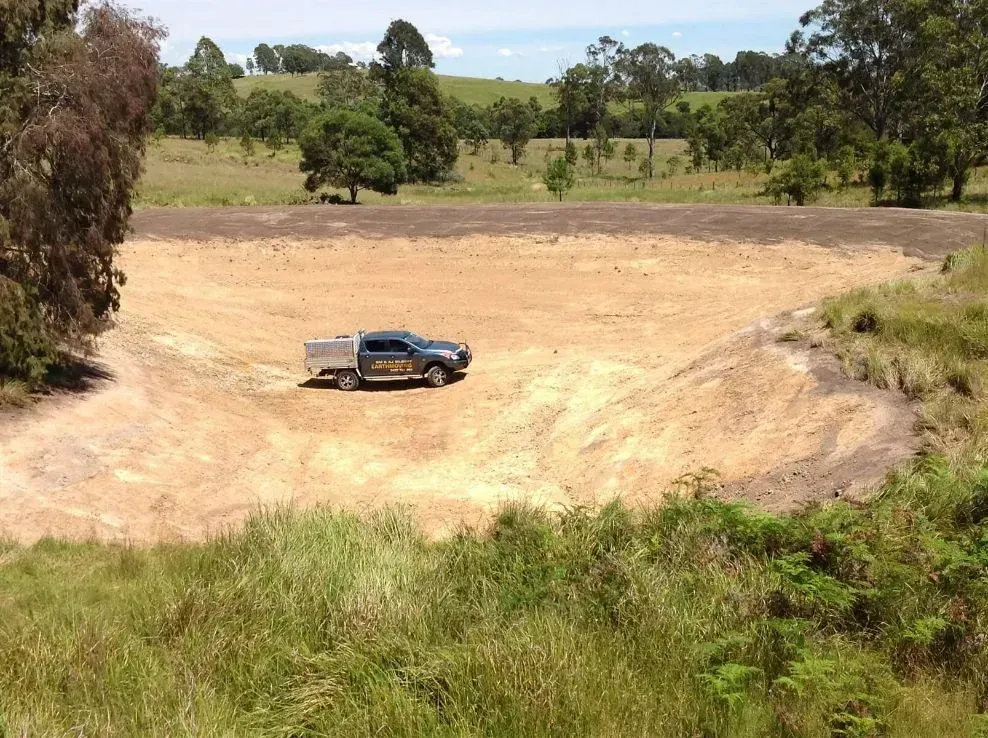 A Blue Truck is Parked in the Middle of a White Dirt Field — S M & A J Gilbert Earthmoving in Mitchells Island, NSW