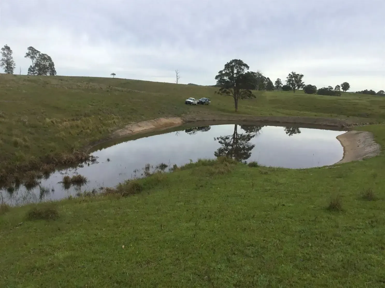 A Vehicle Sits on the Hill in the Background — S M & A J Gilbert Earthmoving in Mitchells Island, NSW