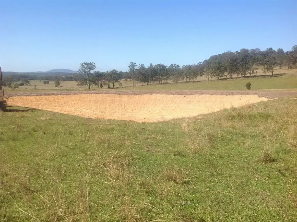A Large Forest With a Large Pile of White Dirt in the Middle of It — S M & A J Gilbert Earthmoving in Mitchells Island, NSW