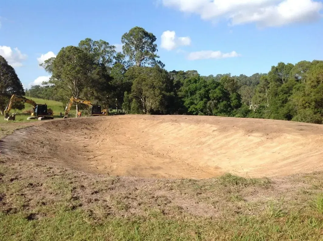 A Large Patch of White Dirt Field With Trees in the Background — S M & A J Gilbert Earthmoving in Mitchells Island, NSW