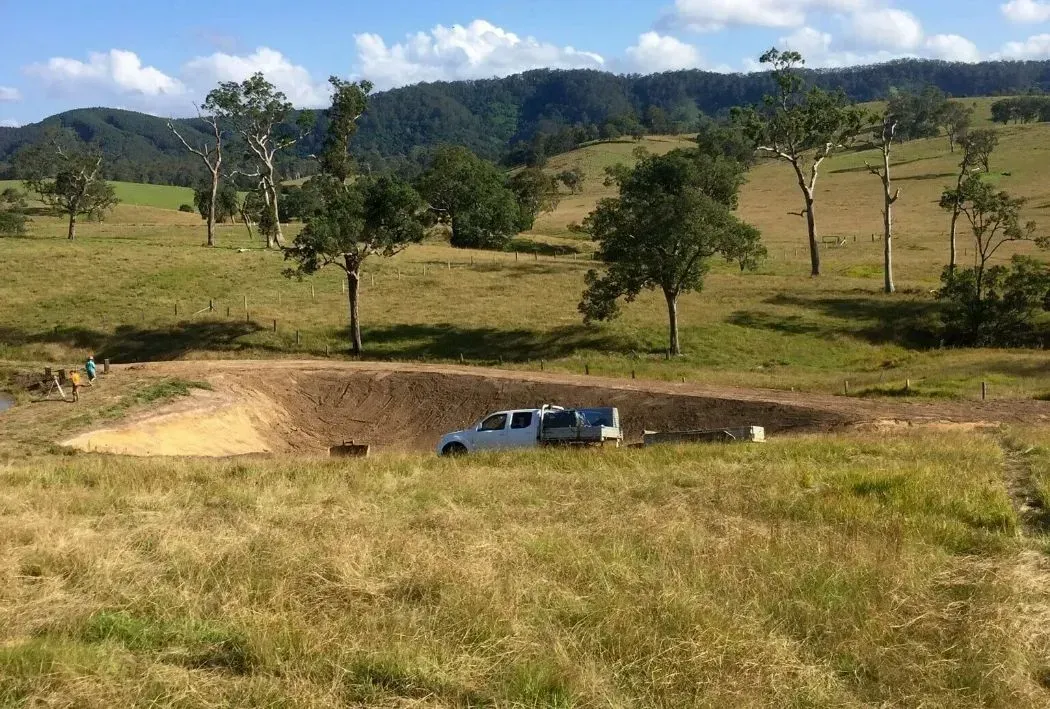 A White Truck is Parked in the Middle of a Big Crater — S M & A J Gilbert Earthmoving in Mitchells Island, NSW