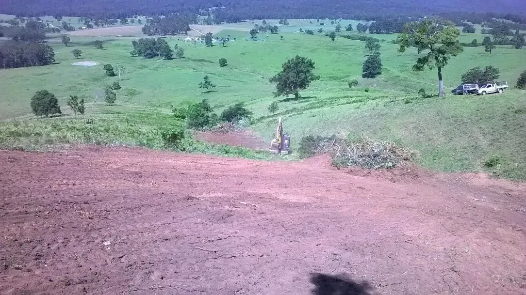 A Person is Riding a Dirt Bike Down a Dirt Hill in a Field — S M & A J Gilbert Earthmoving in Mitchells Island, NSW