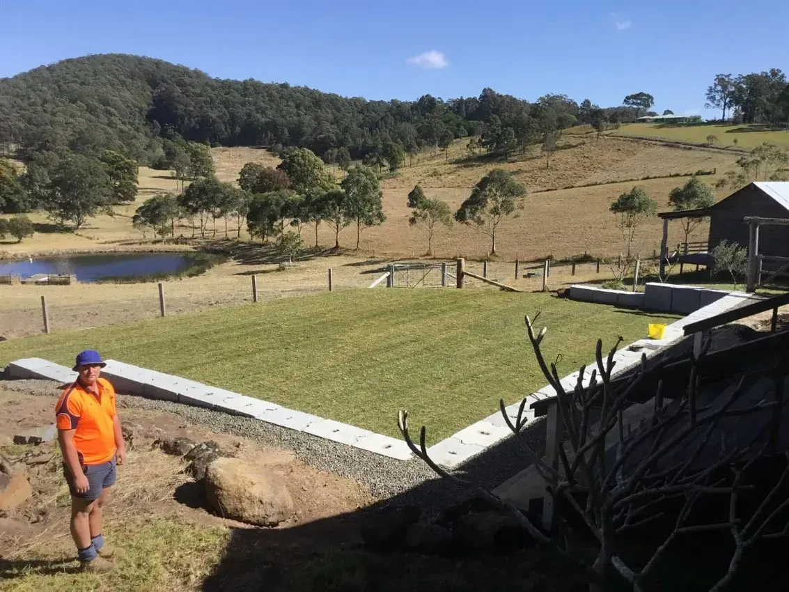 A Tractor is Driving Down a Hill in the Woods At A Slow Pace — S M & A J Gilbert Earthmoving in Mitchells Island, NSW