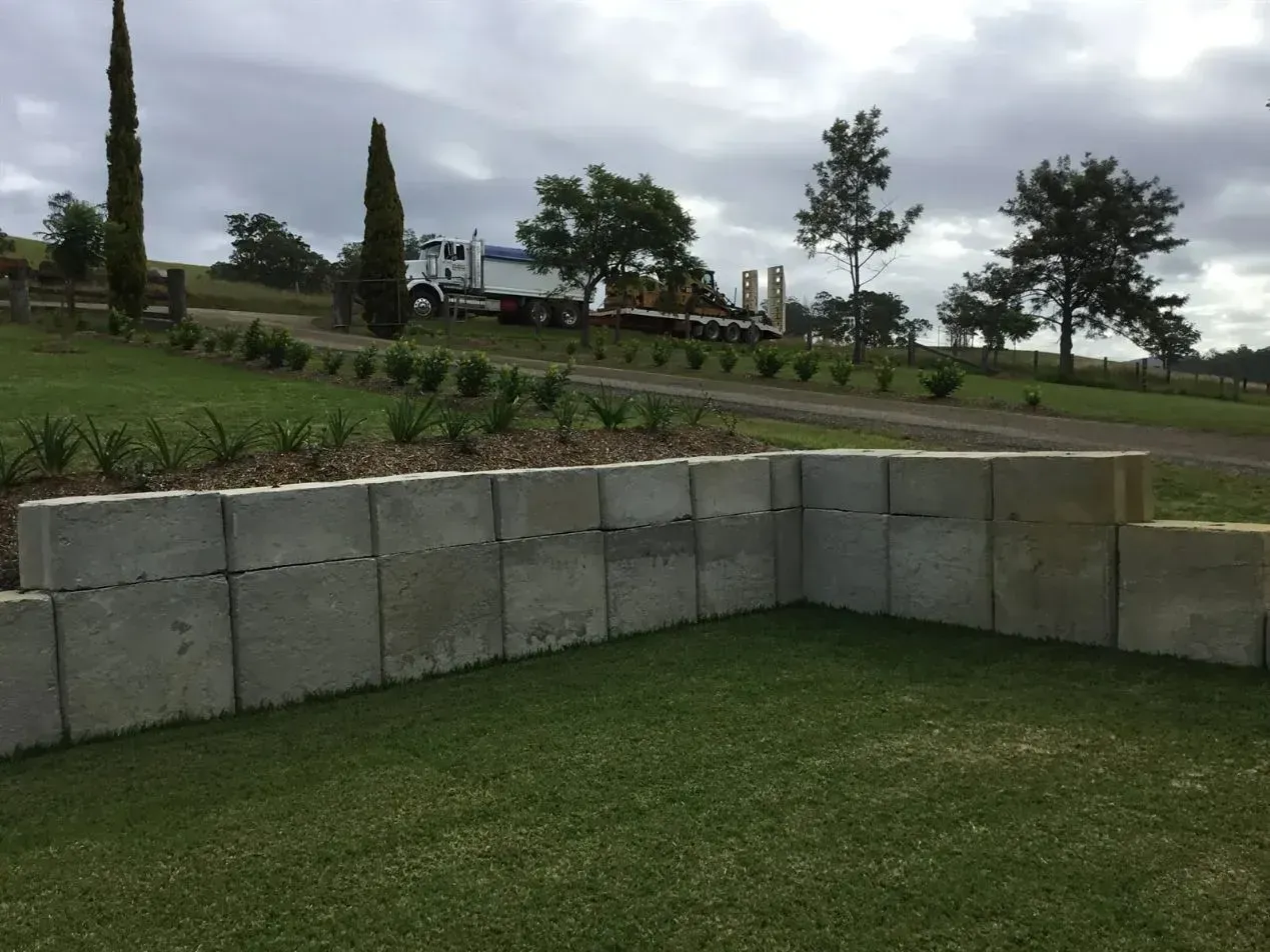 A Truck is Parked Behind A Tree That's Behind A Wall — S M & A J Gilbert Earthmoving in Mitchells Island, NSW