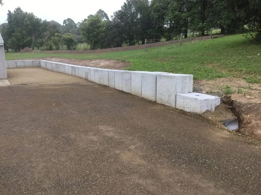 A Concrete Wall is Being Built in the Middle of a Long Dirt Road — S M & A J Gilbert Earthmoving in Mitchells Island, NSW