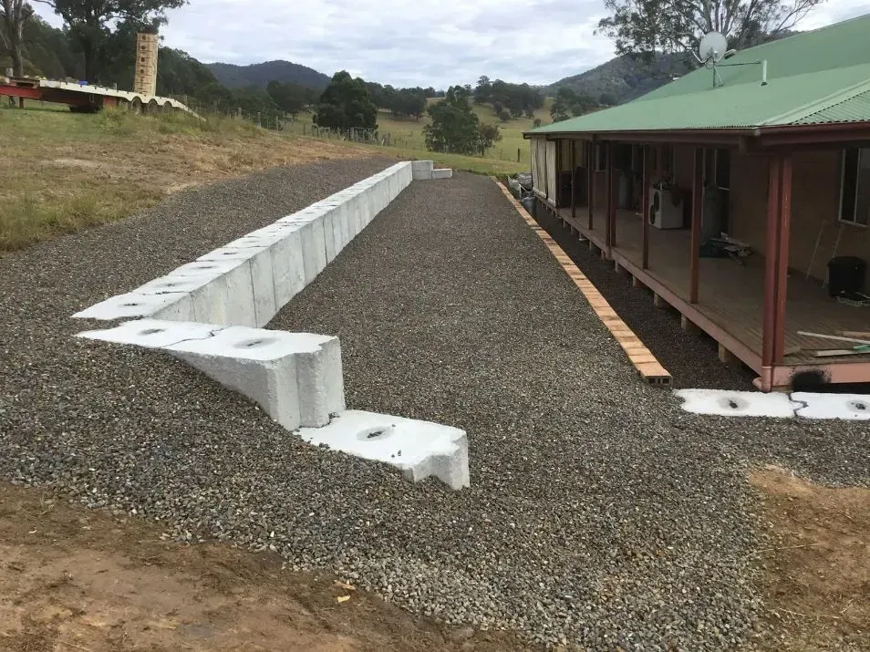 A Concrete Wall is Being Built in Front of a Beautiful House — S M & A J Gilbert Earthmoving in Mitchells Island, NSW