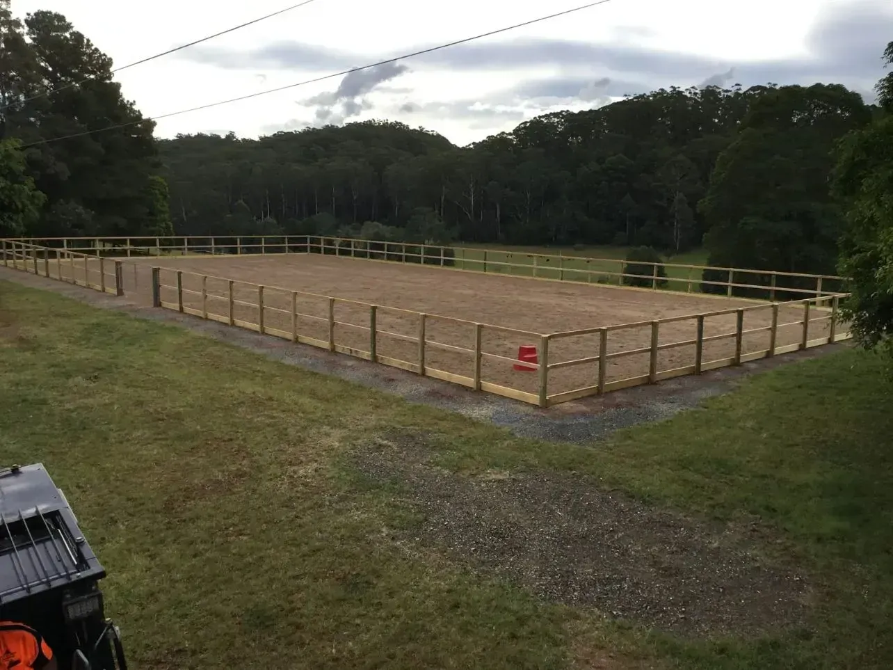 A Large Open Dirt Field With a Wooden Fence Around It — S M & A J Gilbert Earthmoving in Mitchells Island, NSW