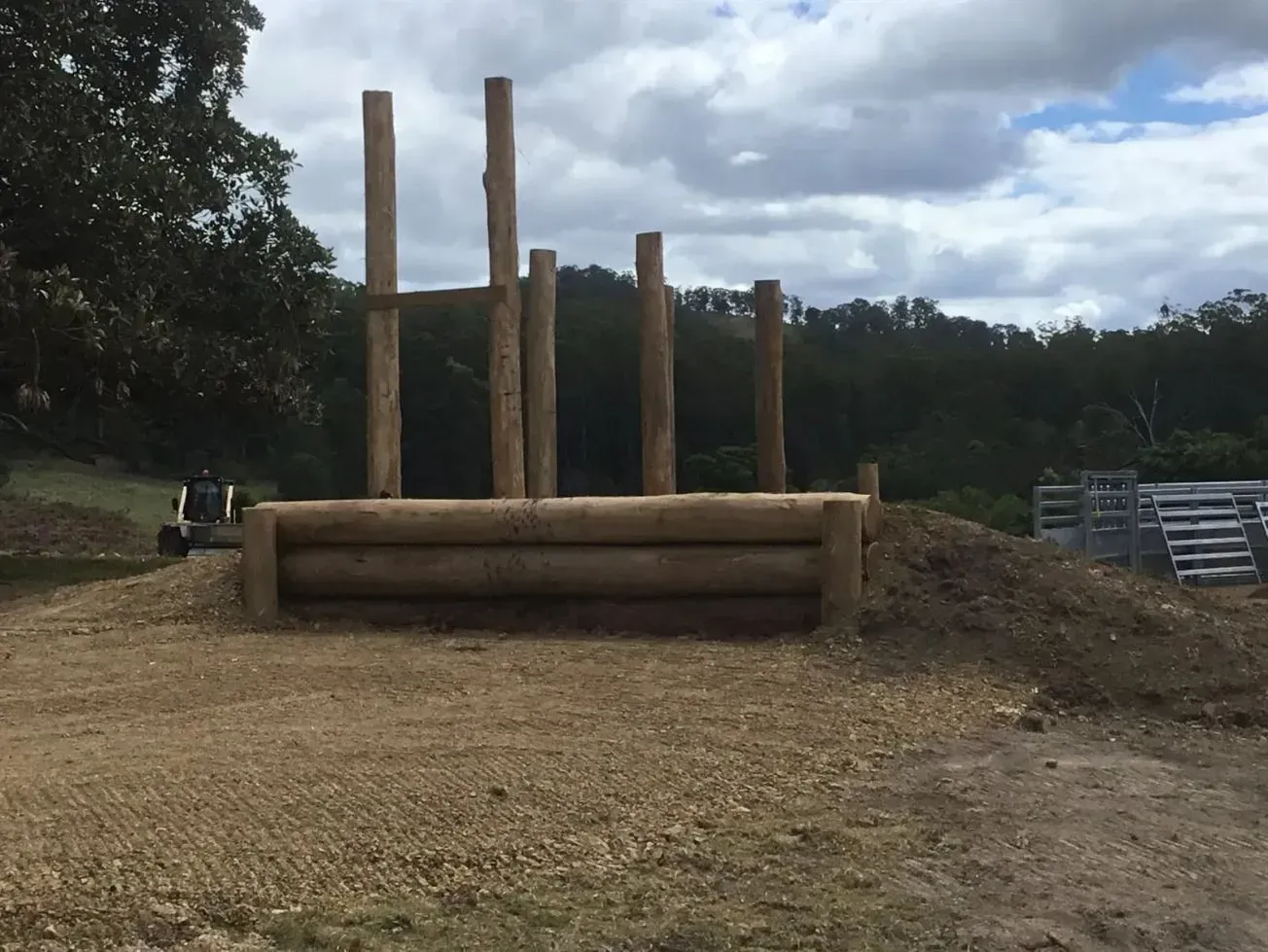 A Pile of Logs is Sitting on Top of a Dirt Hill — S M & A J Gilbert Earthmoving in Mitchells Island, NSW