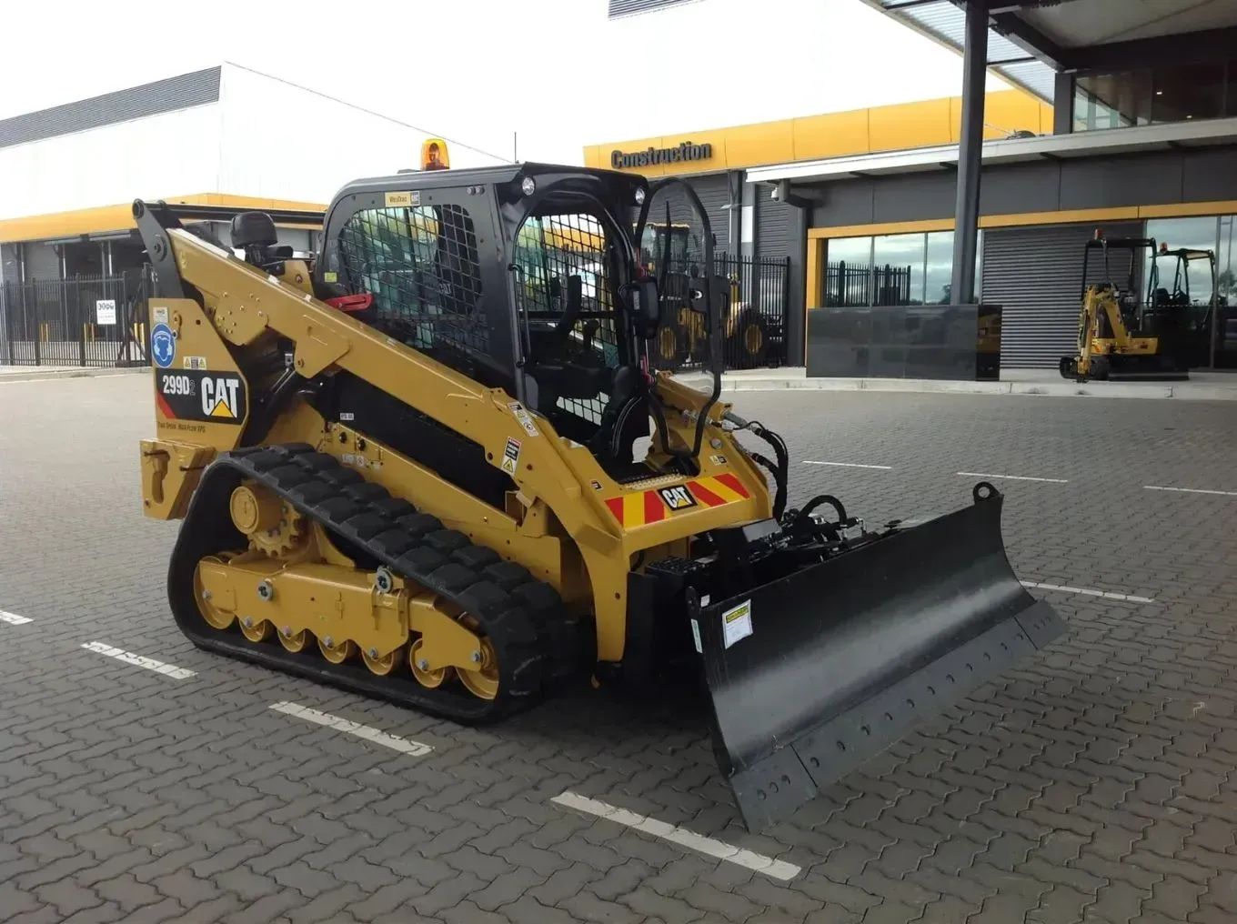 A Cat Bulldozer is Parked in Front of a Building — S M & A J Gilbert Earthmoving in Mitchells Island, NSW