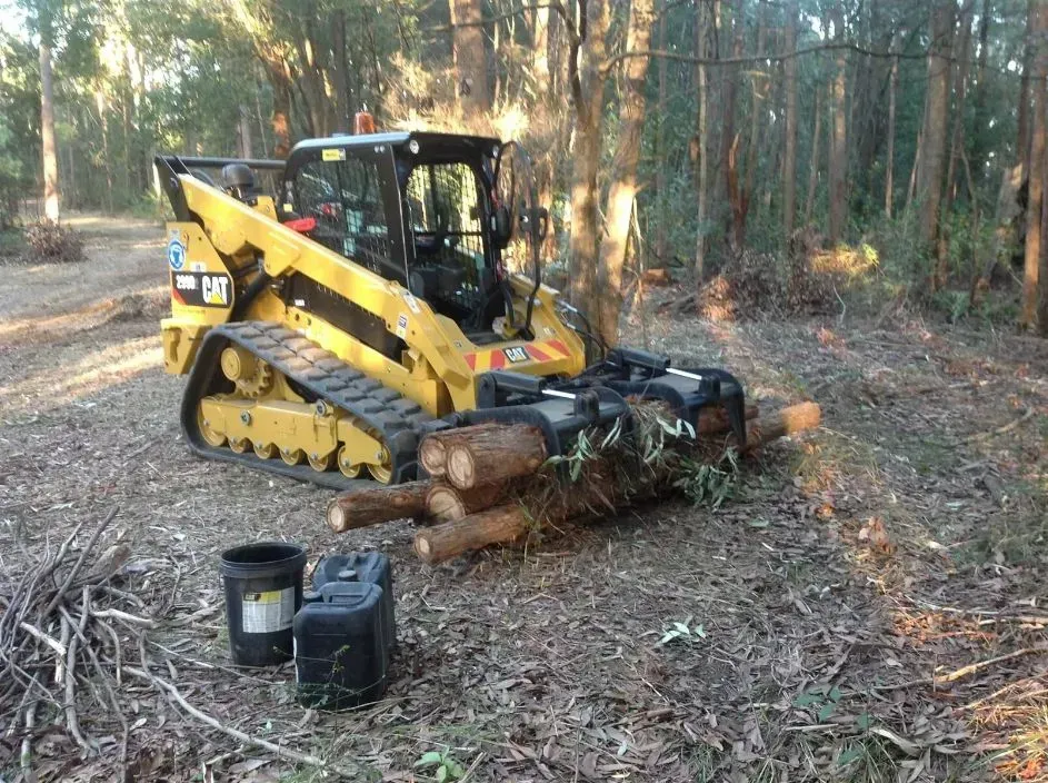 A Large Bulldozer is Sitting in the Middle of a Forest Next to a Pile of Logs — S M & A J Gilbert Earthmoving in Mitchells Island, NSW