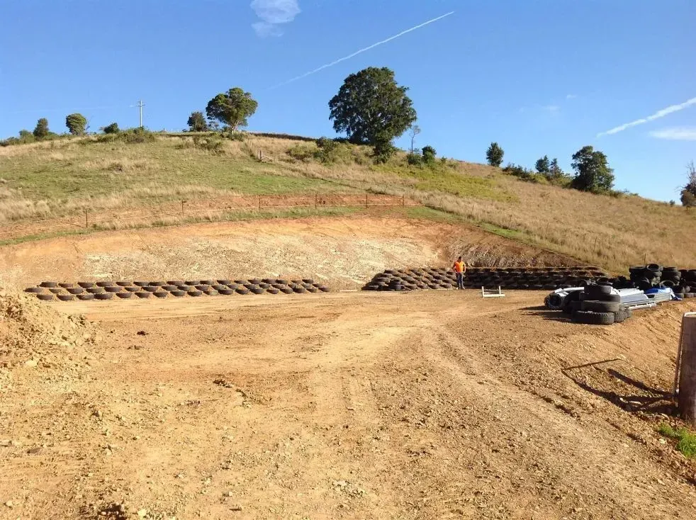 A White Dirt Field With a Hill and Many Tree in the Background — S M & A J Gilbert Earthmoving in Mitchells Island, NSW