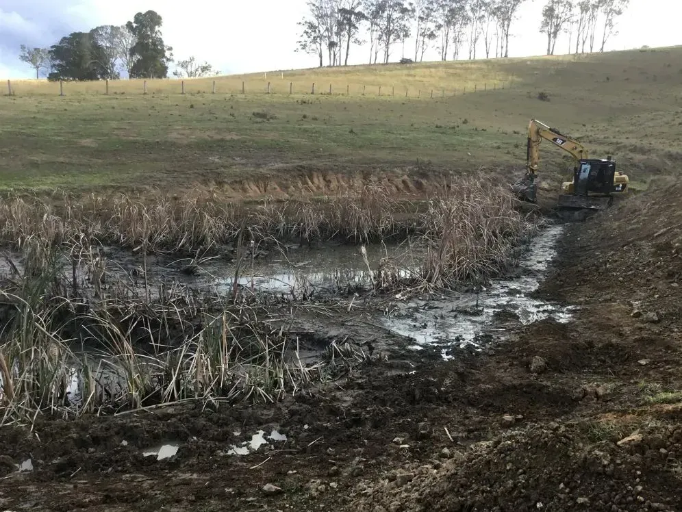 A Bulldozer is Working On A Puddle — S M & A J Gilbert Earthmoving in Mitchells Island, NSW