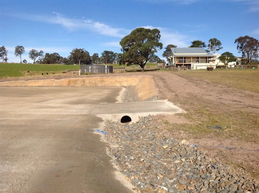 A Dirt Road With a House With Drainage Hole — S M & A J Gilbert Earthmoving in Mitchells Island, NSW