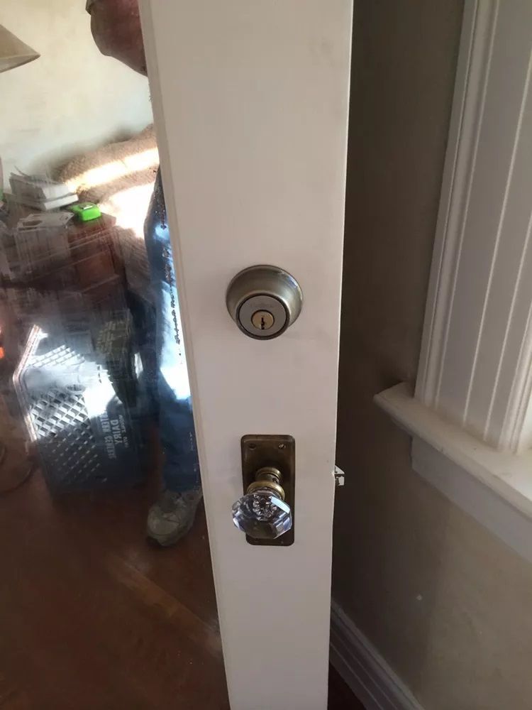 A person is standing next to a door with a lock on it.