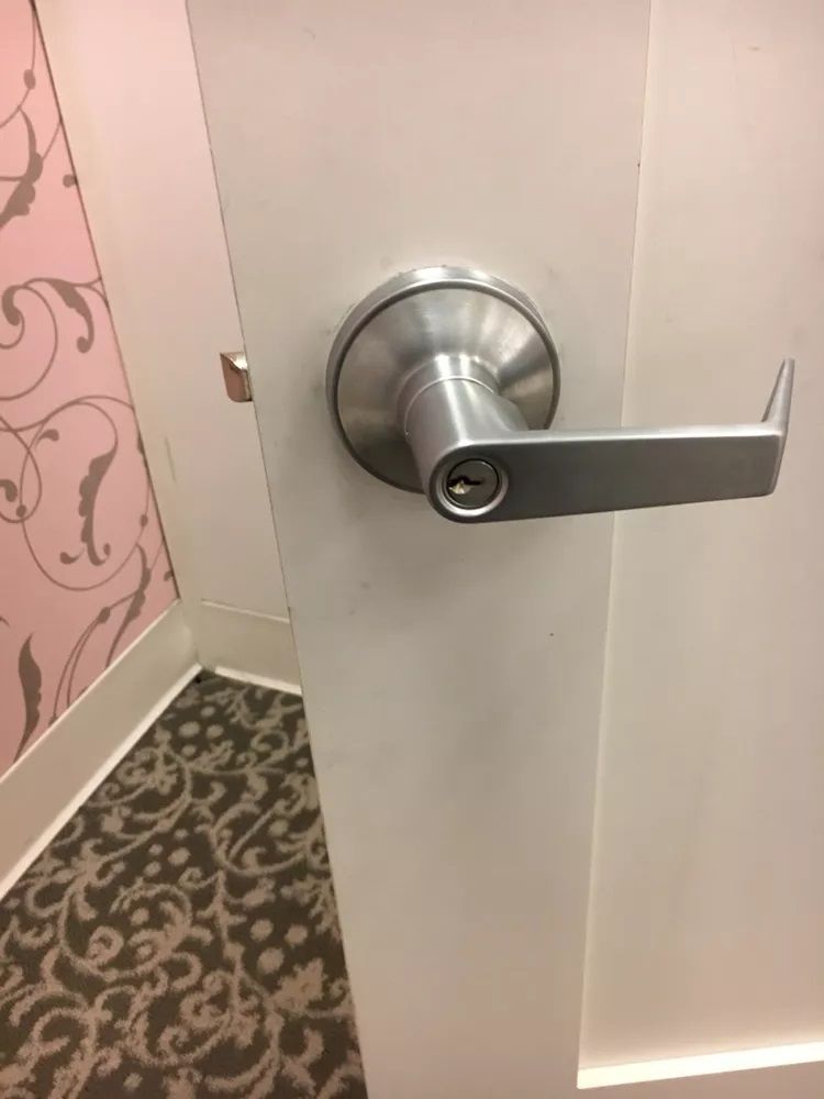 A close up of a door handle on a white door.