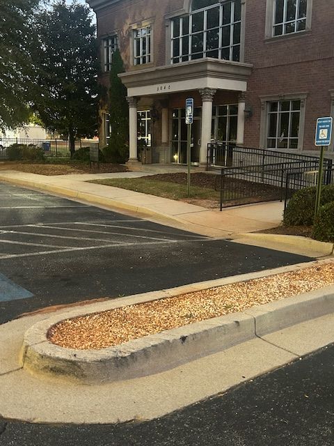 Exterior view of a brick building with a wheelchair ramp and accessible parking space.