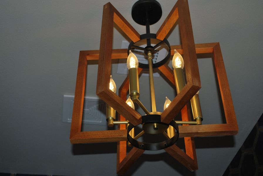 Wooden and brass chandelier with four light bulbs.
