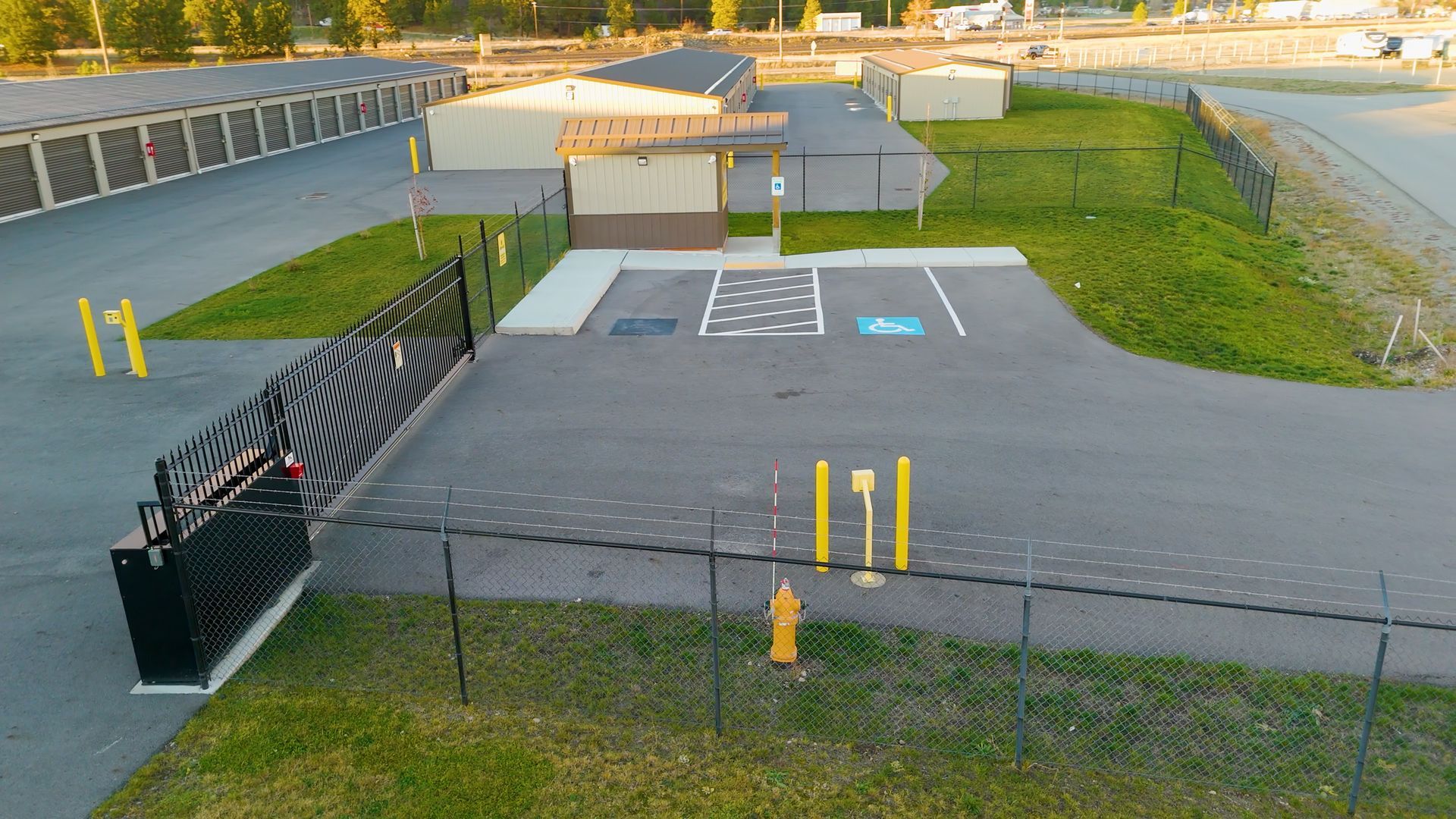 Exterior view of a storage facility entrance. Black gate.