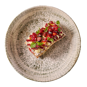 Dessert on a plate: rectangular pastry with fruit topping and powdered sugar.