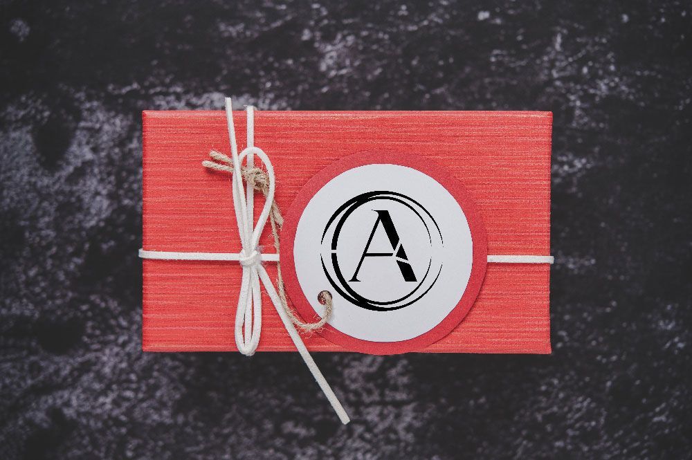 Red gift box tied with string, round label with a black 