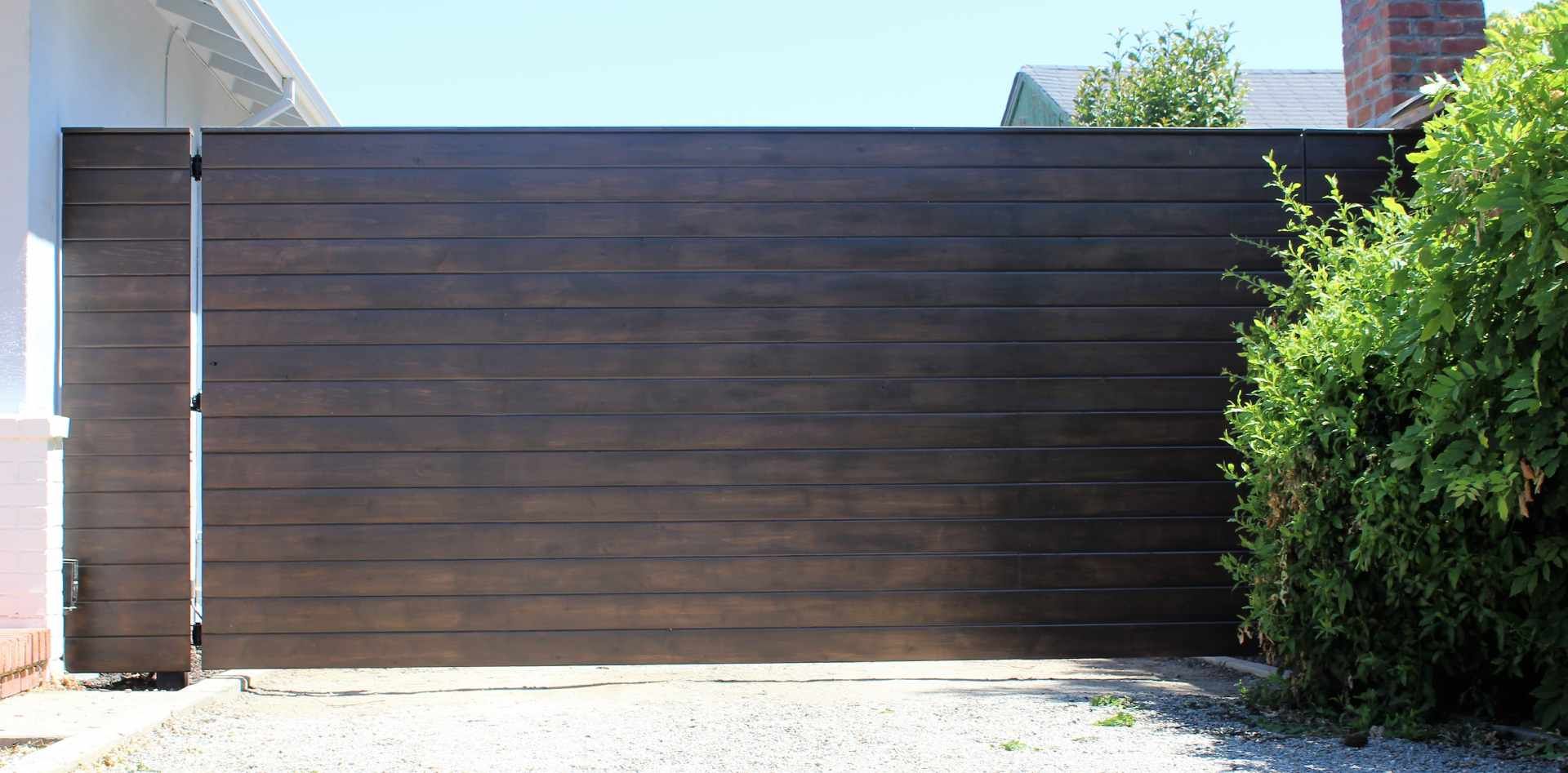 A large wooden gate is sitting in front of a house.