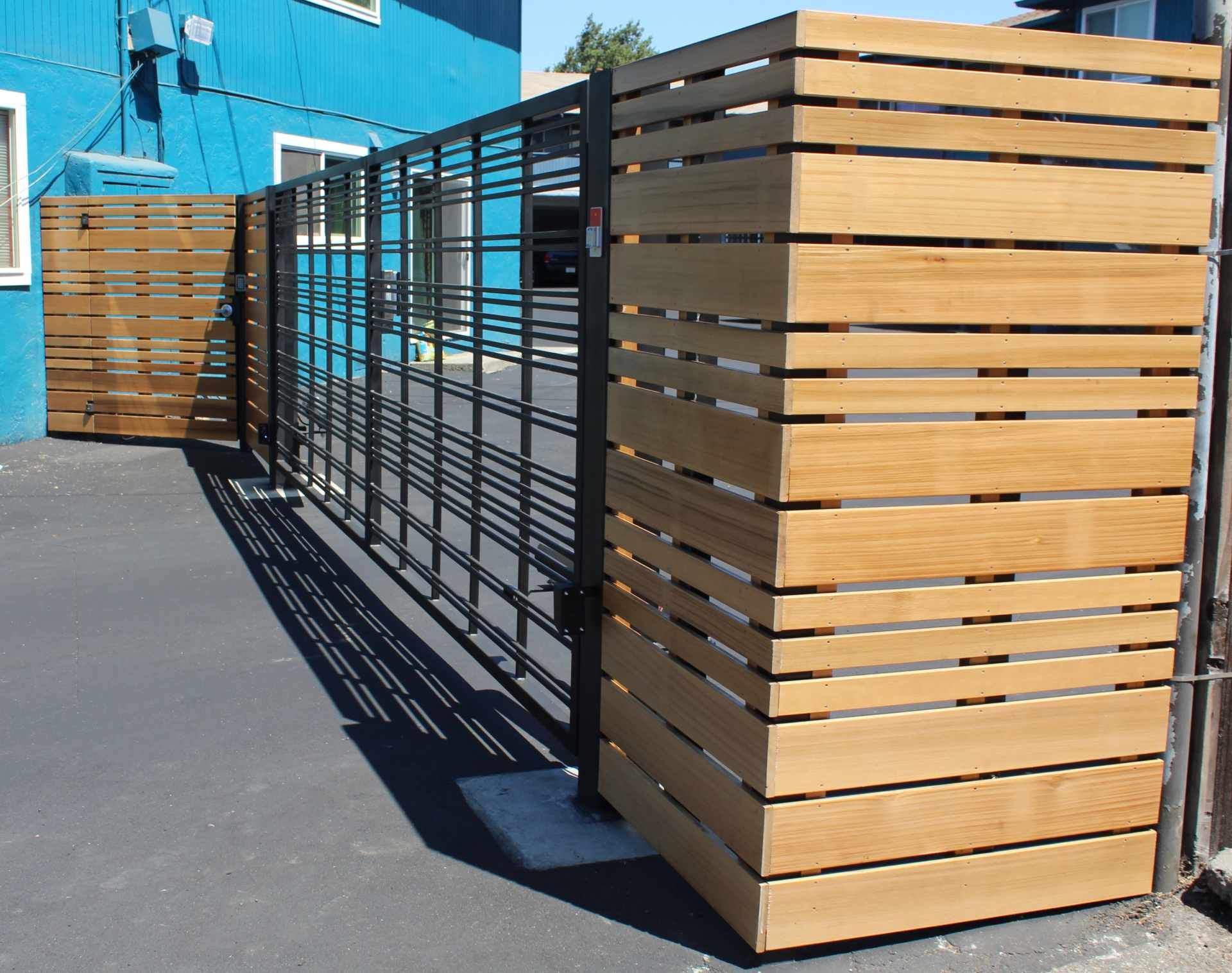 A wooden fence with a blue building in the background