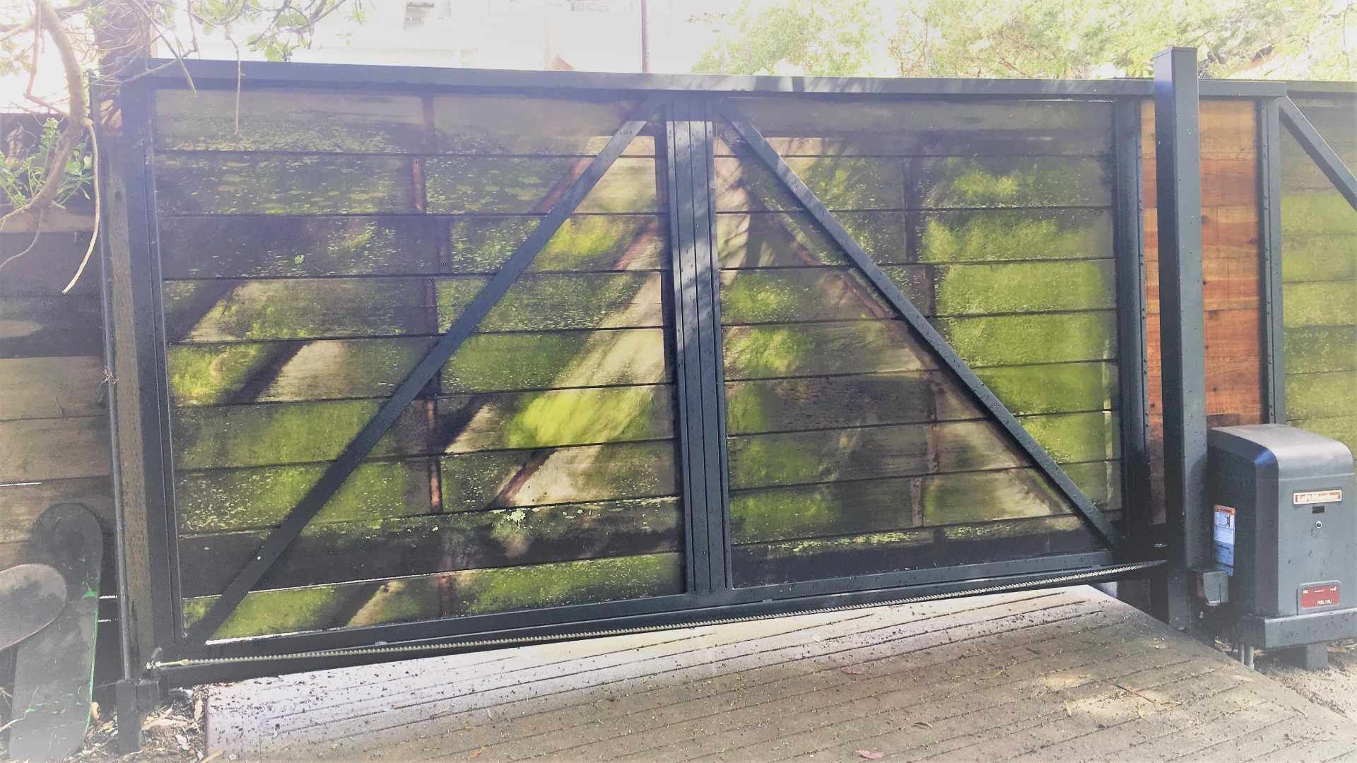 A wooden gate with a black frame and a black box in front of it.