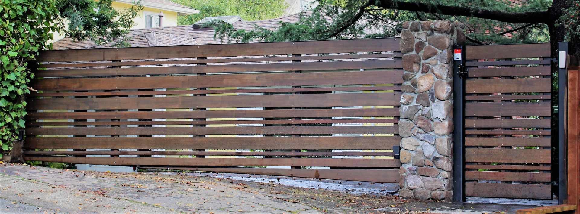 A wooden fence with a stone wall behind it