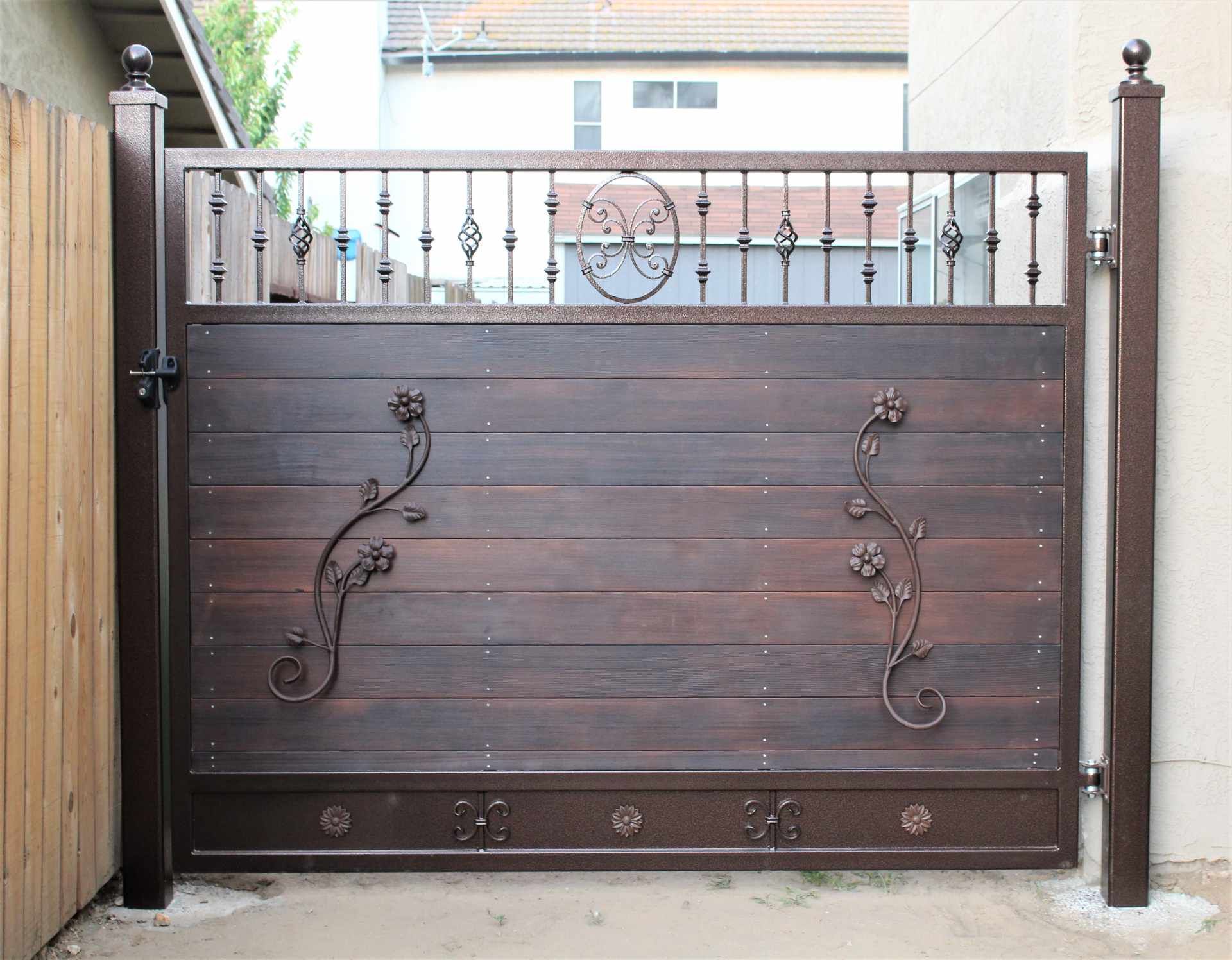 A wooden gate with a wrought iron design on it