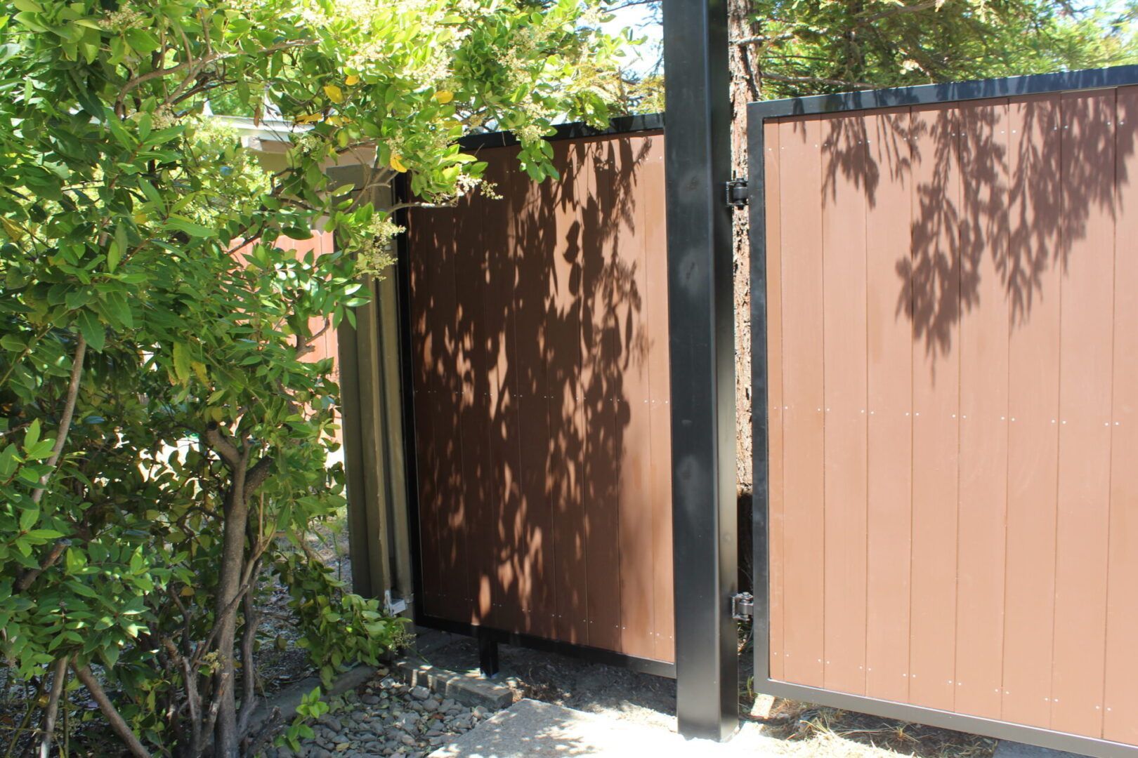 A wooden fence is surrounded by trees and bushes.