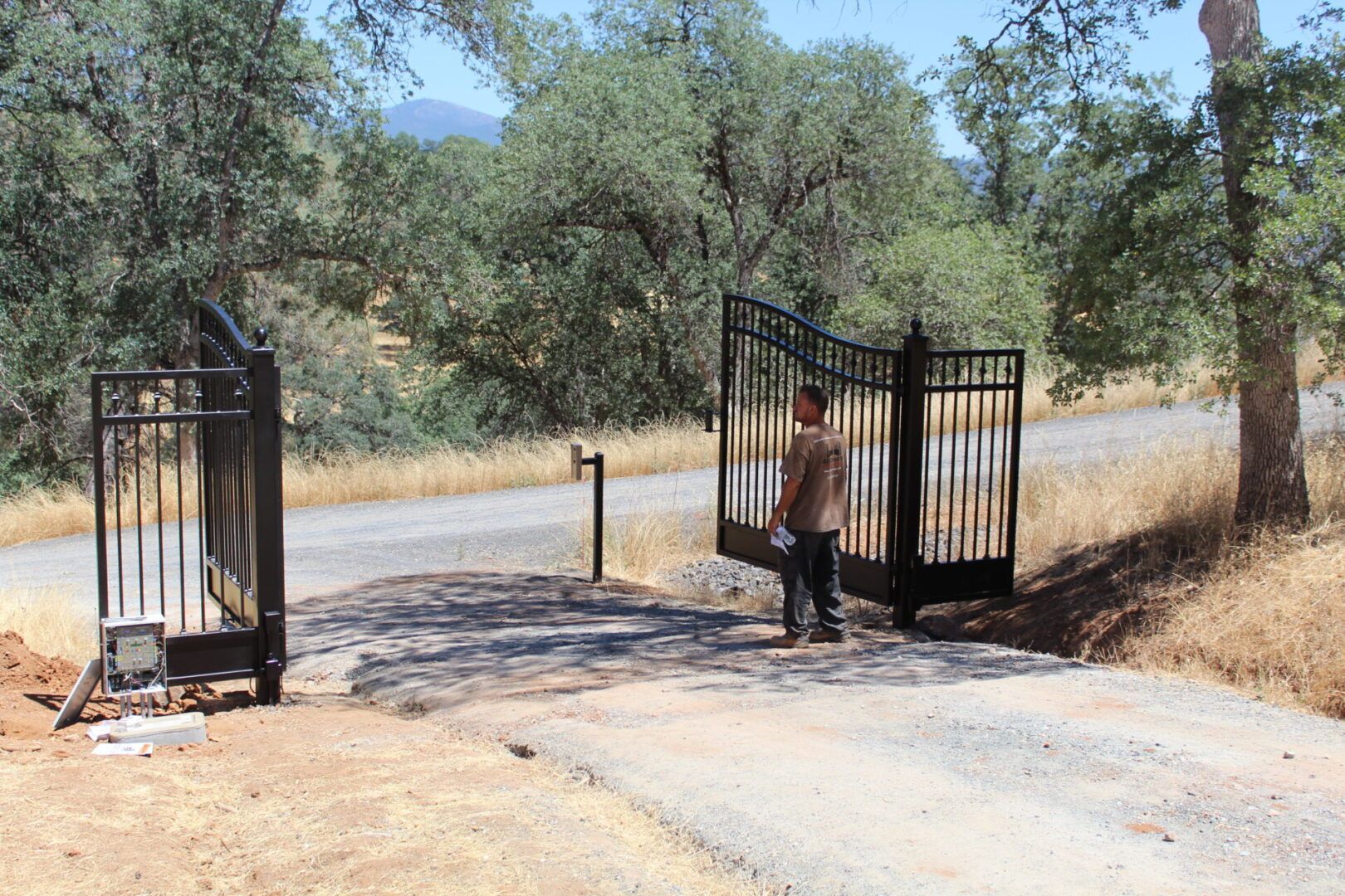 A man is standing in front of an open gate.