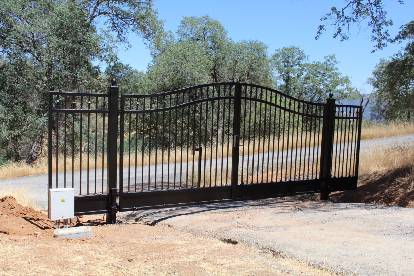 A black wrought iron gate on the side of a road