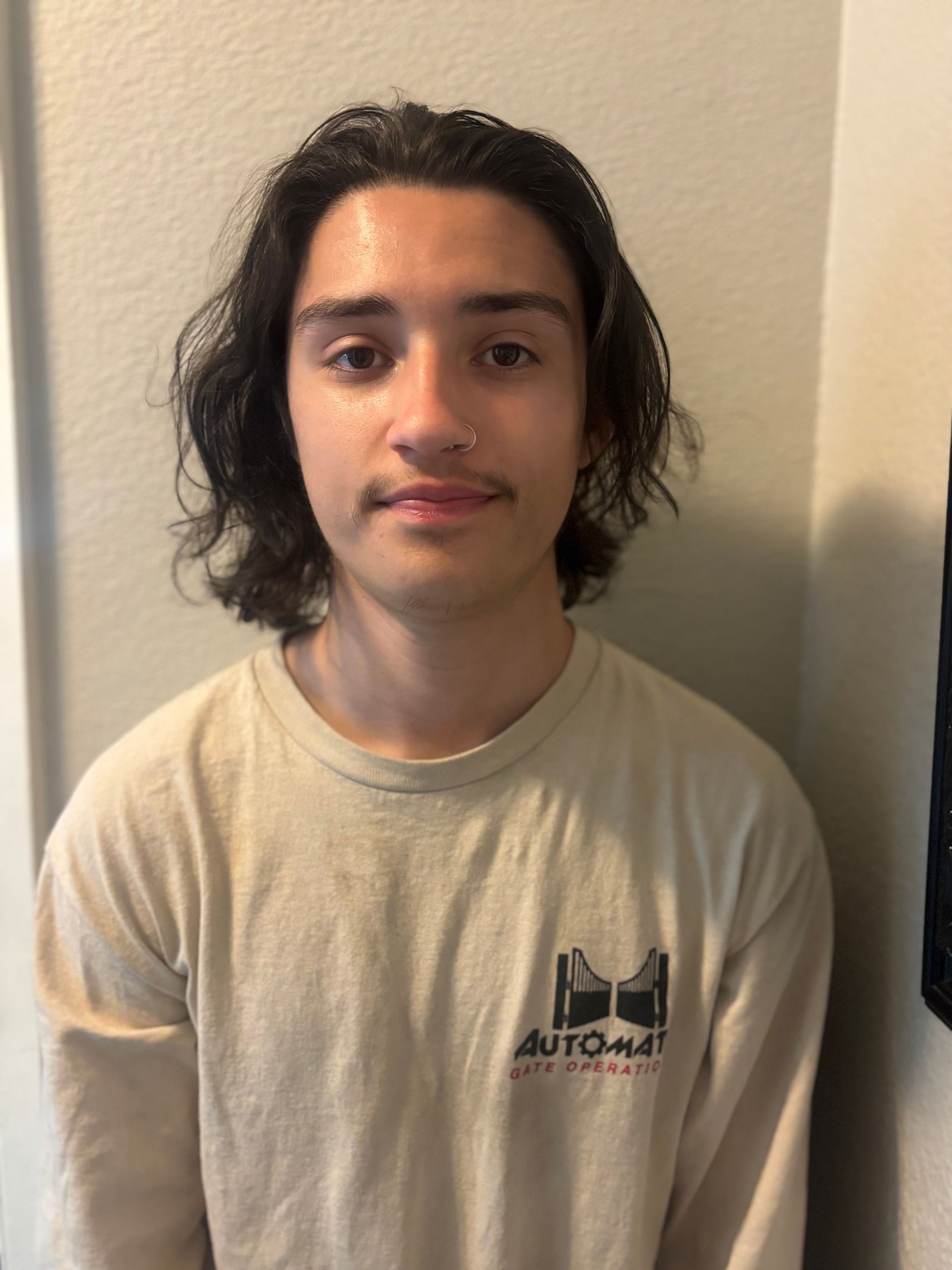 A man with a beard is standing in front of a white van.