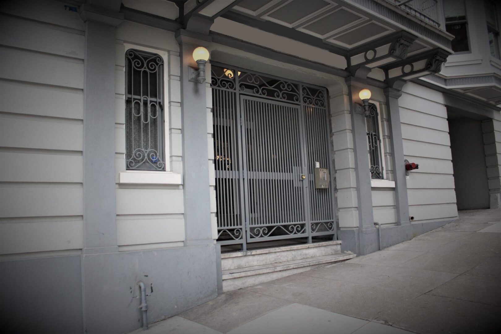 A building with a gate and a fire hydrant in front of it