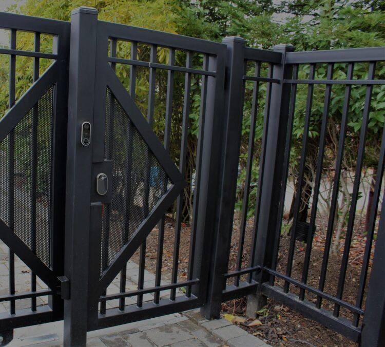 A black fence with a gate that is open